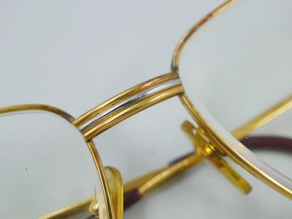 null 
CARTIER. 

Paire de lunettes en plaqué or.

Le pont formé de trois bandes inspirées...