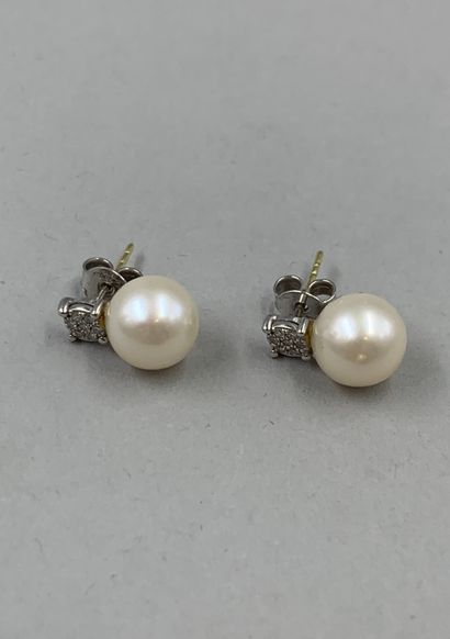 null Pair of 18k white gold stud earrings adorned with cultured pearls of about 8mm...