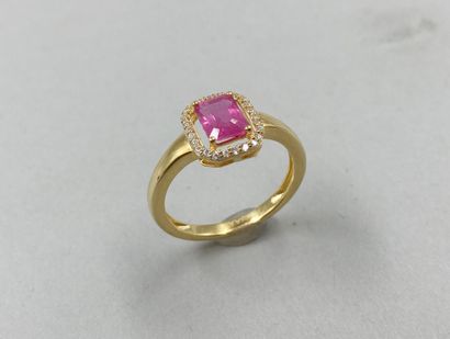 null A vermeil ring set with an emerald-cut pink sapphire surrounded by a line of...