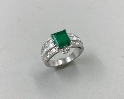 null 18k white gold ring set with a 2 ct emerald in a three-ring setting paved with...