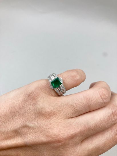 null 18k white gold ring set with a 2 ct emerald in a three-ring setting paved with...