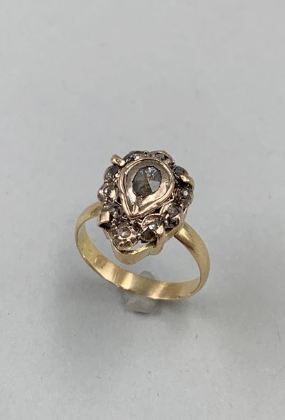 null Yellow gold and silver ring set with a pear-shaped central diamond in a surround...