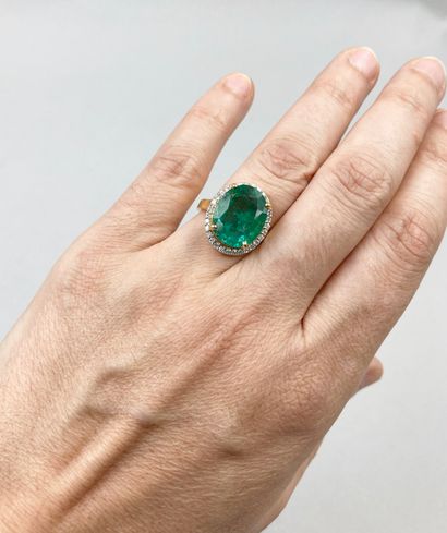 null An 18k yellow gold Pompadour ring set with a large oval emerald weighing approximately...
