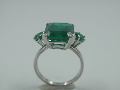 null 18k white gold ring set with an emerald-cut green stone and two green stones....