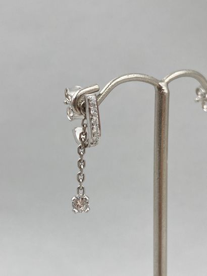 null Pair of 18k white gold earrings with small diamonds, holding a chain finished...