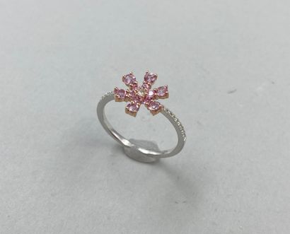 null 18k gold flower ring set with pink sapphires, centered with a diamond, the ring...