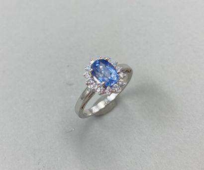 null 18k white gold flower ring set with an oval-cut sapphire weighing approximately...