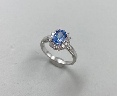 null 18k white gold flower ring set with an oval-cut sapphire weighing approximately...