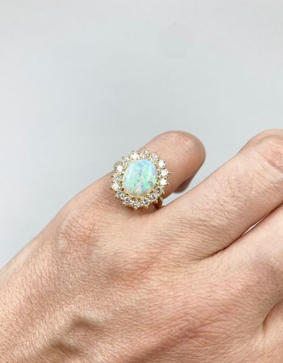 null 18k yellow gold ring centered on an oval opal in a diamond setting. 

PB : 5,90g....