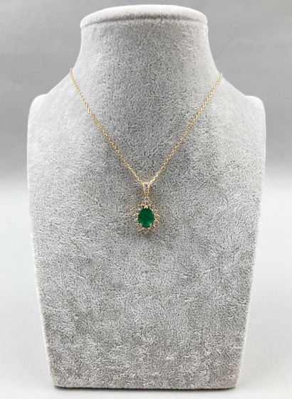 null 18k yellow gold pendant set with a pear cut emerald in a diamond setting.

With...