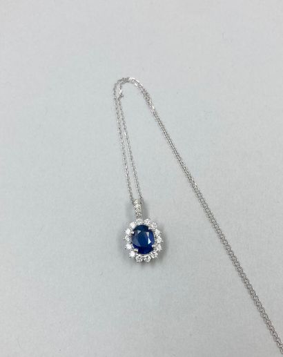 null 18k white gold oval pendant set with a 1.50 ct oval sapphire in a setting of...