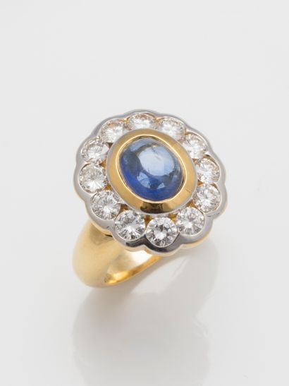 null Daisy ring in 18k yellow gold with a sapphire cabochon surrounded by 12 brilliant-cut...