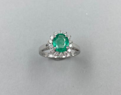 null 18k white gold flower ring set with a 1.40ct oval emerald in a setting of 14...
