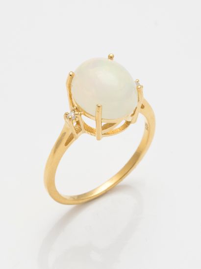 null A vermeil ring set with a cabochon opal of 2cts flanked by two diamonds. 

Gross...