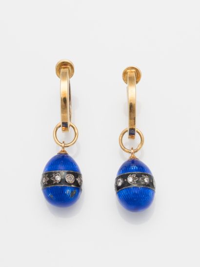 null 
Pair of 18k yellow gold clip earrings holding a blue enamelled egg with a radiating...