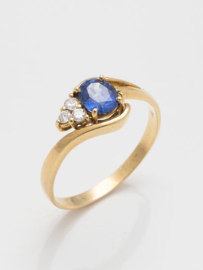 null Yellow gold ring topped with a small oval sapphire flanked by three diamonds....