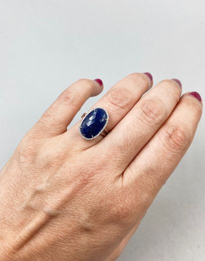 null 18k white gold ring set with an 8ct faceted sapphire surrounded by a line of...