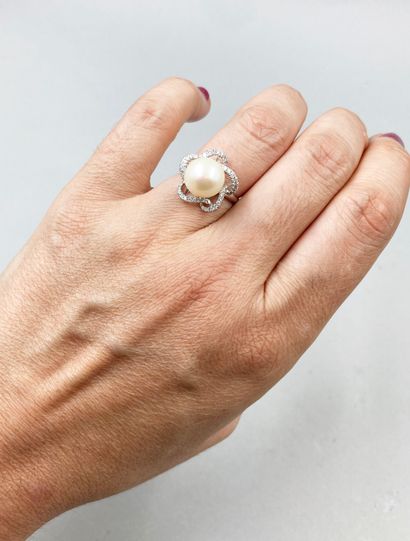 null Flower ring in 18k white gold, centered on a 10mm cultured pearl, the petals...