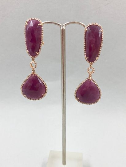 null A pair of 18k rose gold earrings holding faceted rubies surrounded by lines...