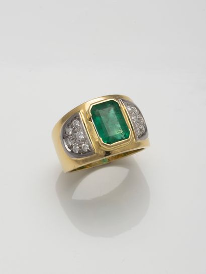 null 18k yellow gold band ring set with a close-set emerald and D-shaped diamonds.

Gross...