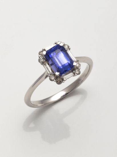 null Ring in 18k white gold surmounted by an emerald-cut tanzanite in a setting of...