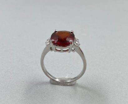 null 18k white gold ring set with a dark orange oval garnet of about 4cts with 3...