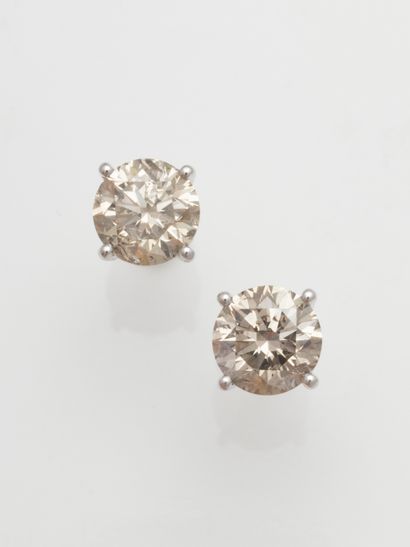 null Pair of 18k white gold stud earrings, each with a brilliant-cut diamond of about...