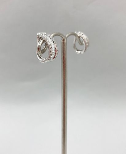 null Pair of 18k white gold ear clips set with a line of tapers diamonds between...
