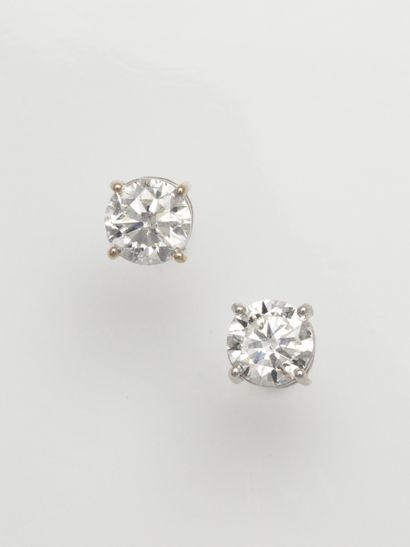 null Pair of 18k white gold earrings each set with a brilliant-cut diamond of about...