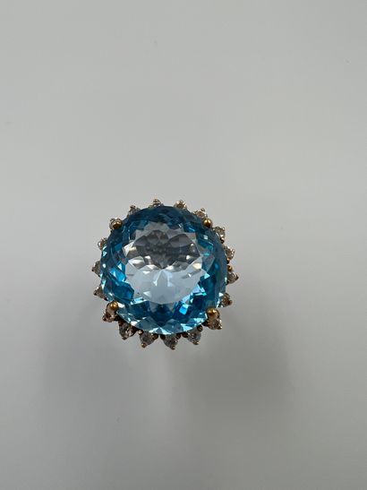 null Silver ring set with a round blue topaz in a circle of white stones.

B : 9,20gr....