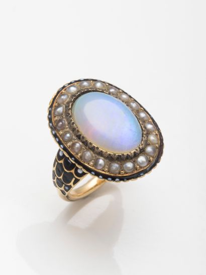 null 18k yellow gold ring centered on an oval cabochon opal in a pearl and black...