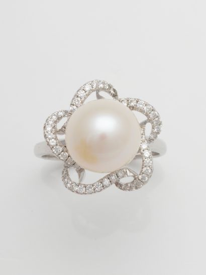 null Flower ring in 18k white gold, centered on a 10mm cultured pearl, the petals...