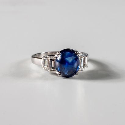 null Ring in 18k white gold with a cabochon sapphire of about 3.50cts and 4 baguette-cut...