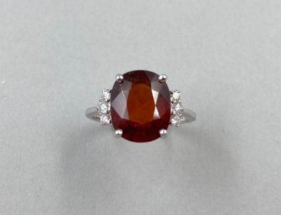 null 18k white gold ring set with a dark orange oval garnet of about 4cts with 3...