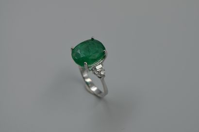 null 18k white gold ring set with a 6cts oval emerald and baguette and brilliant...