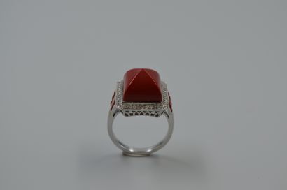 null 18k white gold ring topped by a coral sugarloaf surrounded by a line of diamonds....