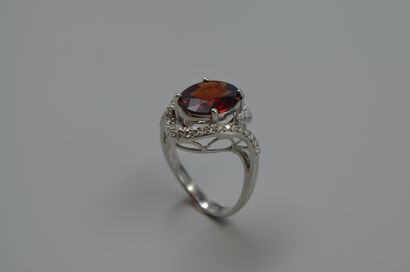 null Tourbillon ring in 18k white gold centered with a garnet in a diamond setting....