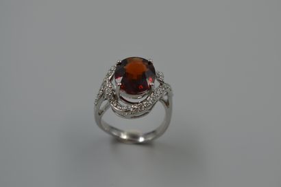 null Tourbillon ring in 18k white gold centered with a garnet in a diamond setting....
