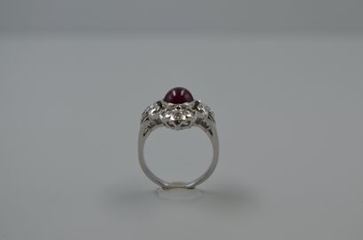 null Platinum ring in the form of an openwork cross centered on a cabochon ruby with...