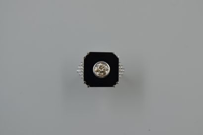 null 18k white gold ring with a cut onyx plate centered by a 1ct diamond in closed...