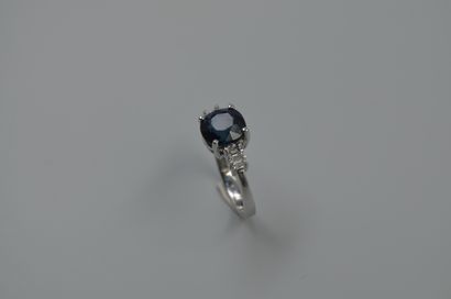null 18k white gold ring set with a 4.01cts natural round sapphire and baguette-cut...