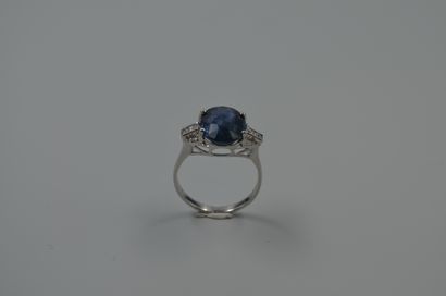 null 18k white gold ring topped with a 5.16cts natural oval sapphire set with baguette...