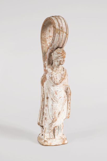 Solid terracotta Tanagra with traces of polychromy.

GREECE,...