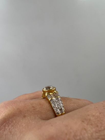 null 18k yellow gold ring set with a 1ct brilliant-cut solitaire diamond and baguette-cut...