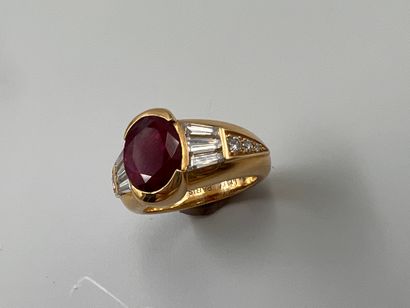 null Bague en or jaune 18k surmontée d'un rubis ovale de 5cts environ accosté de...