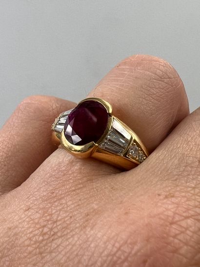 null 18k yellow gold ring surmounted by an oval ruby of about 5cts, with six white...
