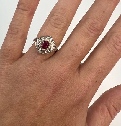null Platinum ring centered on a 1ct oval ruby in a double stylized flower setting...