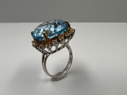 null Silver ring set with a round blue topaz in a circle of white stones.

B : 9,20gr....