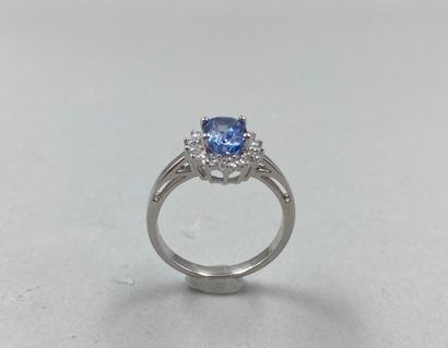 null 18k white gold flower ring set with an oval-cut sapphire weighing approximately...