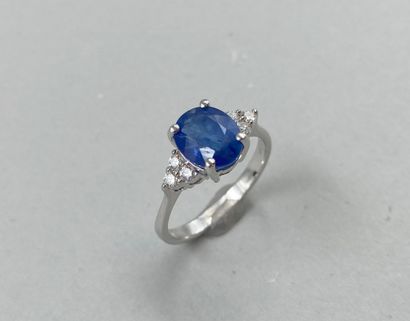 null 18k white gold ring set with a 3cts oval sapphire and 3 diamonds forming a triangle....